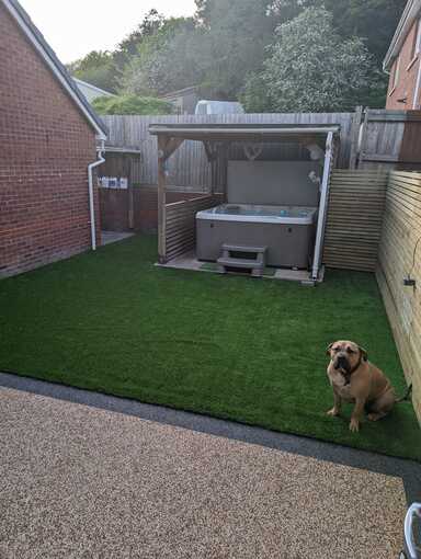 Photo from patio doors of completed resin patio installation by RNM Resins including a newly turfed garden in property in Pontardawe Swansea.
