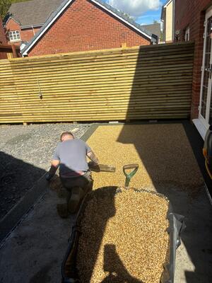 RNM Resins installer in process of laying Sand storm resin mix in centre area of patio at property in Pontardawe, Swansea