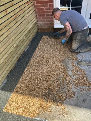 RNM Resins installer laying Sand storm resin mix in centre area of patio at property in Pontardawe, Swansea
